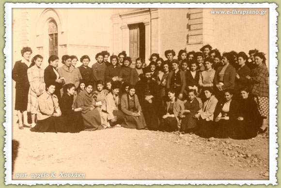 Φωτογραφία εποχής με κοπέλες του κατηχητικού σχολείου Θραψανού περιστοιχίζουσες τον αείμνηστο ιερέα Εμμ. Γενειατάκη έξωθεν του Ιερού Ναού της Υψώσεως του Τιμίου Σταυρού